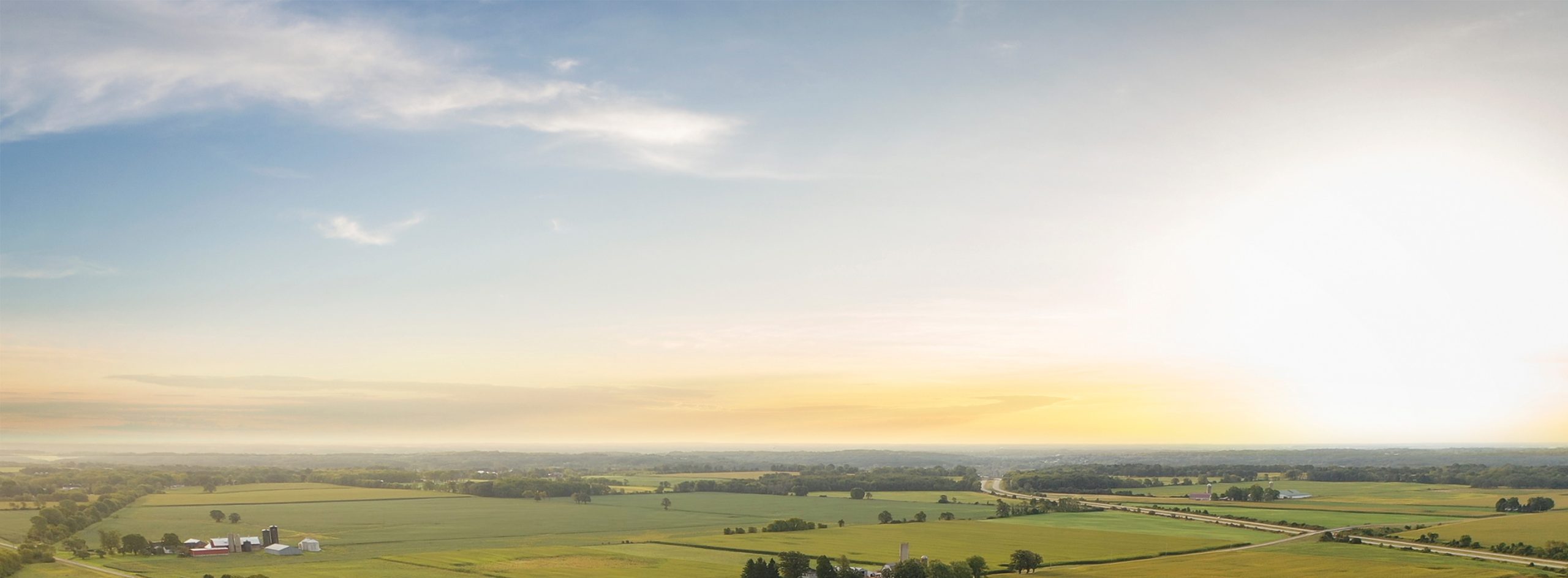 image of distant horizon of rural midwest farmland with a sunrise